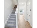 Bright hallway with gray carpet stairs and wood-look tile flooring throughout at 7270 Deer Valley Cir, Tampa, FL 33635