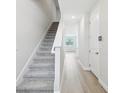 Bright hallway with wood-look tile flooring and carpeted stairs leading to the upper level at 7272 Deer Valley Circle, Tampa, FL 33635