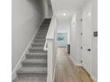 Bright hallway featuring wood flooring, a carpeted staircase, and neutral color palette at 7274 Deer Valley Cir, Tampa, FL 33635