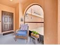 Inviting covered entrance with a cozy chair and view of the home's address on the garage at 10607 Standing Stone Drive, Wimauma, FL 33598