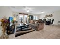 Open living room and dining area featuring tile floors, neutral tones, and lots of natural light at 10607 Standing Stone Drive, Wimauma, FL 33598