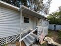 Quaint home featuring a covered entryway with steps and a charming white picket fence, perfect for welcoming guests at 12485 Land St, Largo, FL 33773