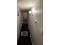 Hallway with neutral walls, lighting fixture and black carpet, leading to various rooms within the home at 12485 Land St, Largo, FL 33773