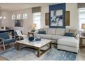Inviting living room with a plush sectional, stylish decor, and large windows for natural light at 2718 Wise River Lane, Zephyrhills, FL 33539