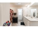 Well-lit bathroom with double sinks, granite countertops, tiled floor, and a shower with a patterned curtain at 3715 Capri Coast, Plant City, FL 33565