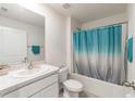 Bright bathroom featuring a shower with a blue curtain, and a vanity with a granite countertop at 3715 Capri Coast, Plant City, FL 33565