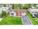 Charming single-story home with brick accents, well-maintained lawn, and a mature palm tree at 7400 Mitchell Ranch Rd, New Port Richey, FL 34655