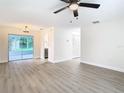 Bright living room featuring neutral walls, modern flooring, and sliding glass doors to the patio at 7400 Mitchell Ranch Rd, New Port Richey, FL 34655