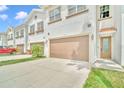Charming townhome exterior featuring a two-car garage, lush lawn, and a well-maintained facade at 8614 Miramar Terrace Cir, Temple Terrace, FL 33637
