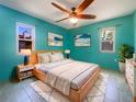 Vibrant bedroom featuring teal walls, modern furniture, and plenty of natural light at 111 Englewood Garden Ct, Englewood, FL 34223