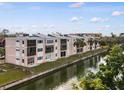 Exterior view of condo building near water featuring balconies and palm trees in a waterfront community at 2486 Caring Way # 17A, Port Charlotte, FL 33952
