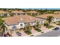 Aerial view of townhome complex with brick paved driveways, garages, and lush landscaping at 4062 Overture Cir # 4062, Bradenton, FL 34209