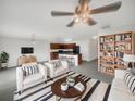 Open-concept living room featuring modern decor, a ceiling fan, and seamless flow to a kitchen with a breakfast bar at 11510 Southern Creek Dr, Gibsonton, FL 33534