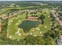 Expansive golf course view with scenic pond, tree coverage, and residential houses in a well-maintained community at 12387 Eastpointe Dr, Dade City, FL 33525