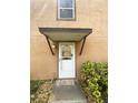 Inviting front entrance featuring a classic white door, decorative window and protective awning at 1857 Clearbrooke Dr, Clearwater, FL 33760