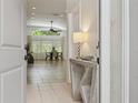 Bright and inviting foyer with neutral tile flooring, view of the dining room, and modern decor at 13405 Fawn Springs Dr, Tampa, FL 33626