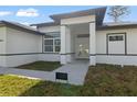 Inviting entryway with a Tesla Solar Roof sign and modern architectural design at 2551 Alhaven Ter, North Port, FL 34286