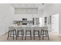 Bright, modern kitchen with stainless steel appliances, a large island, bar seating, and decorative backsplash at 2551 Alhaven Ter, North Port, FL 34286