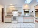 Bright kitchen featuring white appliances, ample cabinet space, and a skylight for natural lighting at 1481 Newton St, Port Charlotte, FL 33952