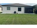 A view of the back of the house with an expansive green lawn at 2137 Apian Way, Port Charlotte, FL 33953