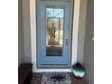 View of a glass front door with welcome mat and decorative accents at 2137 Apian Way, Port Charlotte, FL 33953