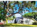 Back exterior view showcasing an enclosed screened-in patio with outdoor furniture at 2806 W Shelton Ave, Tampa, FL 33611