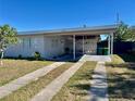 Exterior view of the home with an attached carport and well-maintained front yard with nice landscaping at 681 Dalton Blvd, Port Charlotte, FL 33952