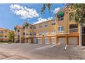 Condo building featuring private garages, stairs to upper units, balconies, and lush landscaping under a clear sky at 10764 70Th Ave # 3305, Seminole, FL 33772