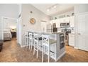 Well-lit kitchen with white cabinets, granite countertops, stainless steel appliances, and bar seating at 10764 70Th Ave # 3305, Seminole, FL 33772