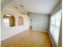 Spacious living room with hardwood floors, neutral paint and arched doorways, providing an open feel at 12092 Rockford St, Spring Hill, FL 34608