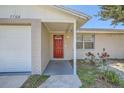 Inviting entrance with a red front door, brick accents, and a covered porch at 7708 Belah Dr, New Port Richey, FL 34653