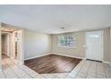 Open-concept living room with tiled flooring, wood accents, and a view of the entryway at 7708 Belah Dr, New Port Richey, FL 34653
