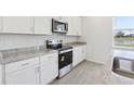 Kitchen featuring white cabinets, stainless steel appliances, granite countertops, and a view of a serene pond at 1878 Draughton Dr, Zephyrhills, FL 33541