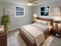Comfortable main bedroom featuring natural light, neutral colors, hardwood bed frame, and stylish lamps at 3213 Bigelow Dr, Holiday, FL 34691