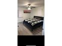 Cozy bedroom with sleek gray floors, ceiling fan and picture window with a view at 2902 Little Rd, Valrico, FL 33596