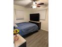 Bright bedroom features wood-look floors, a ceiling fan, and a view of the sunflowers at 2902 Little Rd, Valrico, FL 33596