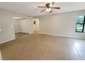 Bright living room featuring tile flooring, neutral-toned walls, a ceiling fan and ample natural light at 1424 Pine Glen Ln # D2, Tarpon Springs, FL 34688