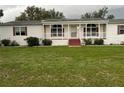 Inviting single-story home featuring a cozy front porch and a well-manicured front lawn at 4435 Tevalo Dr, Valrico, FL 33596