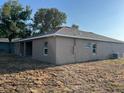 The back of this single-story home features a covered patio, and simple landscaping at 2346 Logsdon St, North Port, FL 34287
