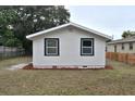 Exterior shot of house, showing the backyard with grass, mulch, and newly trimmed trees at 316 21St W St, Palmetto, FL 34221