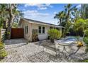 Charming home with metal bench and table, surrounded by white gravel and lush landscaping at 913 Tennessee Ln, Sarasota, FL 34234