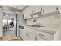 Galley kitchen features white cabinets, laminate countertops, and stainless refrigerator at 2900 Cove Cay Dr # 7C, Clearwater, FL 33760