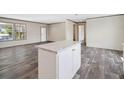 Open living space with hardwood floors and lots of natural light through a window at 8857 Highpoint Blvd, Brooksville, FL 34613
