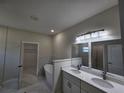 Bright bathroom featuring double sinks, marble floors, a soaking tub and open access to the closet at 2310 Logsdon St, North Port, FL 34287