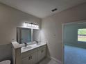 Modern bathroom features a double vanity with white cabinets and countertop, with a neutral color palette at 2310 Logsdon St, North Port, FL 34287