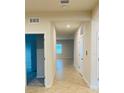 Bright hallway with tiled flooring leading to various rooms, showcasing open floor plan at 29307 Meadowcroft Ave, Wesley Chapel, FL 33544