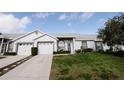 Charming home featuring a well-manicured lawn and inviting entry with cozy outdoor seating at 4217 Avanti Cir, New Port Richey, FL 34655