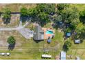 Aerial view of a property featuring a pool and a long driveway surrounded by lush landscaping and mature trees at 6901 W Dormany Rd, Plant City, FL 33565