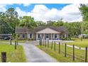 Charming single-story brick home featuring a well-manicured lawn, mature trees, and a welcoming front porch at 6901 W Dormany Rd, Plant City, FL 33565
