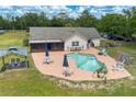 Aerial view of a backyard with a kidney-shaped pool, patio furniture, screened in porch, and a gazebo at 6901 W Dormany Rd, Plant City, FL 33565